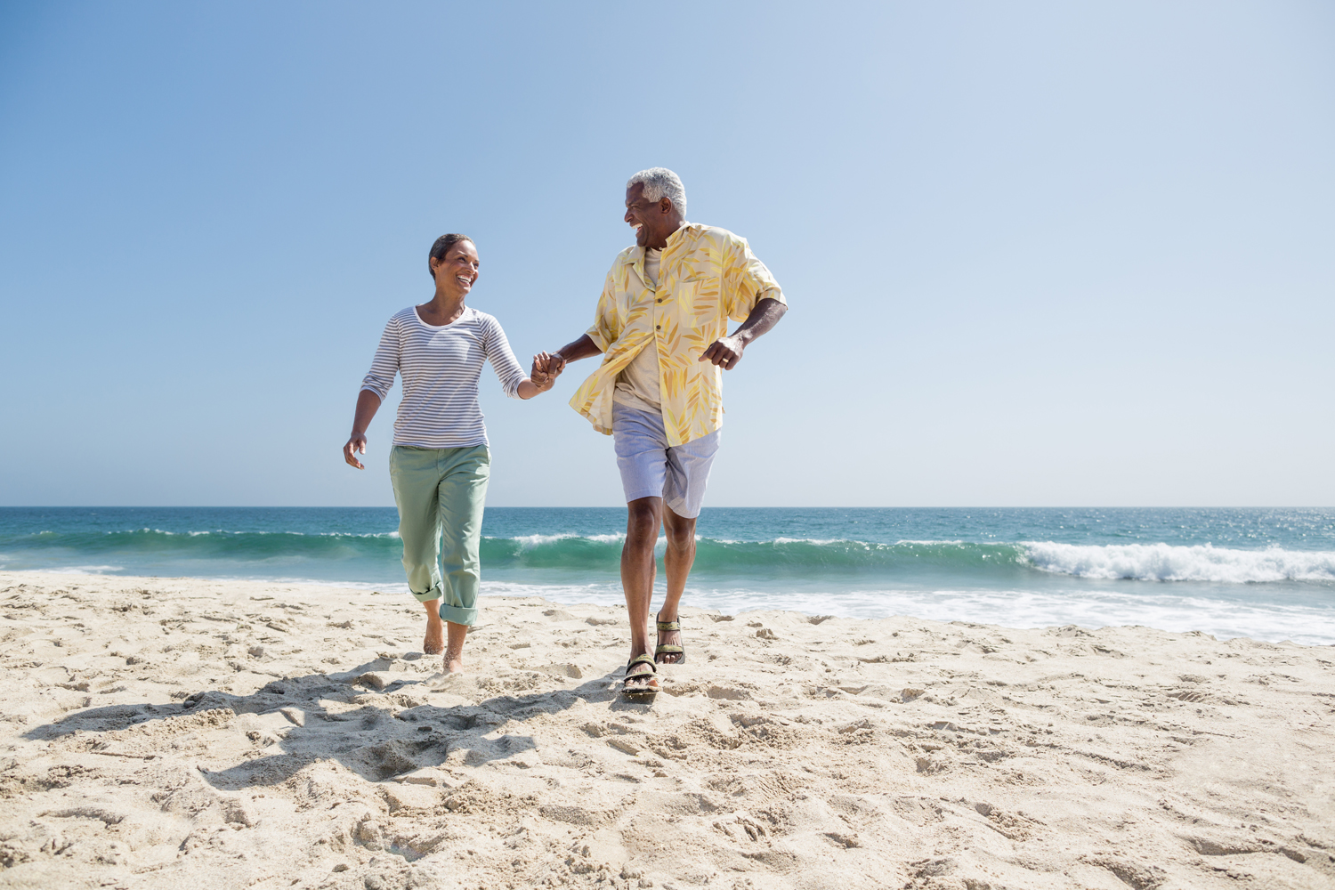 Couple running on the beach in California