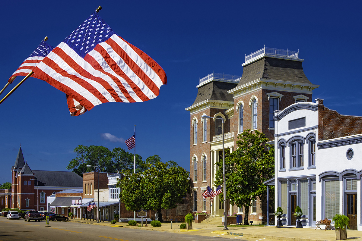 American Flags flying in a small town square.